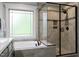 Modern bathroom features tiled shower, soaking tub and frosted window at 335 Gwendolyn Way, Fuquay Varina, NC 27526