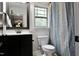 Tastefully decorated bathroom with granite countertop, toilet, and shower with blue and green curtain at 335 Gwendolyn Way, Fuquay Varina, NC 27526