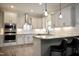Modern kitchen featuring white cabinets, granite countertops, stainless steel appliances, and stylish pendant lighting at 335 Gwendolyn Way, Fuquay Varina, NC 27526