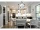 Bright and open kitchen and dining area with stainless steel appliances, light cabinets, and wood floors at 335 Gwendolyn Way, Fuquay Varina, NC 27526