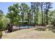 Backyard pool with wooden deck, ladders, and shade umbrellas surrounded by a lush, green lawn at 335 Gwendolyn Way, Fuquay Varina, NC 27526