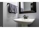 A stylish powder room is equipped with modern fixtures, a pedestal sink, and a decorative towel at 335 Gwendolyn Way, Fuquay Varina, NC 27526