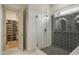 Modern bathroom featuring a glass-enclosed shower with black honeycomb and white subway tile, leading to a walk-in closet at 337 Sunset Hill Ln, Wendell, NC 27591