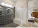 Spa-like bathroom with glass-enclosed shower, bench, and eye-catching black honeycomb tile, leads to main bedroom at 337 Sunset Hill Ln, Wendell, NC 27591