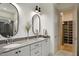 Bright bathroom with double sinks and sleek oval mirrors, opening up to a walk-in closet with shoe shelving at 337 Sunset Hill Ln, Wendell, NC 27591