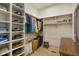 Organized walk-in closet featuring built-in shelves for shoes, hanging clothes, and wooden floors at 337 Sunset Hill Ln, Wendell, NC 27591