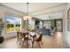 Open-concept dining area with large windows, a modern chandelier, and seamless flow into the adjacent living space at 337 Sunset Hill Ln, Wendell, NC 27591