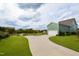 Beautiful green home featuring a long driveway, attached garage, and well-manicured lawn near a pond at 337 Sunset Hill Ln, Wendell, NC 27591