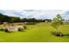 Picturesque pond surrounded by a green lawn, tasteful landscaping, and views of nearby community homes at 337 Sunset Hill Ln, Wendell, NC 27591