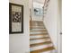 Staircase featuring a light wood handrail, white trim, and natural light from the window on the landing at 337 Sunset Hill Ln, Wendell, NC 27591