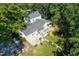 Aerial shot of white two-story house featuring mature trees and backyard pond at 3521 Banks Rd, Raleigh, NC 27603