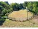 Fenced arena surrounded by mature trees at 3521 Banks Rd, Raleigh, NC 27603