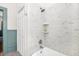 This bathroom has a white tile shower with a shower head and shelves at 3521 Banks Rd, Raleigh, NC 27603