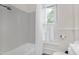 Bright bathroom featuring white subway tile and a window with white shutters at 3521 Banks Rd, Raleigh, NC 27603