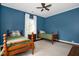 Bedroom with two twin beds, ceiling fan, and a window with natural light at 3521 Banks Rd, Raleigh, NC 27603