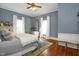 This bedroom features blue wallpaper, hardwood floors, and two windows at 3521 Banks Rd, Raleigh, NC 27603