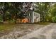 A charming two-story home, nestled among mature trees, features a welcoming porch and a tranquil setting at 3521 Banks Rd, Raleigh, NC 27603
