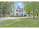 Charming two-story home with black shutters and covered porch surrounded by mature trees at 3521 Banks Rd, Raleigh, NC 27603