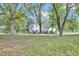Two-story home with black shutters, surrounded by mature trees and a green lawn with a long driveway at 3521 Banks Rd, Raleigh, NC 27603
