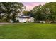 Wide backyard view of white home with garage and basketball hoop at 3521 Banks Rd, Raleigh, NC 27603
