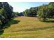 Expansive grassy field surrounded by mature trees at 3521 Banks Rd, Raleigh, NC 27603