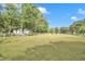 Expansive grassy land featuring scattered trees under a bright blue sky at 3521 Banks Rd, Raleigh, NC 27603