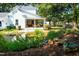 Backyard pond with waterfall feature and view of covered back porch with outdoor seating at 3521 Banks Rd, Raleigh, NC 27603