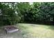 Spacious backyard featuring lush greenery, mature trees, a garden, and a fence at 3521 Piedmont Dr, Raleigh, NC 27604