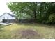 Large backyard with a deck, garden area, mature trees, and partial fencing at 3521 Piedmont Dr, Raleigh, NC 27604