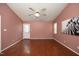 Bright bedroom featuring hardwood floors, ceiling fan, and back door access at 3521 Piedmont Dr, Raleigh, NC 27604