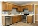 Well-lit kitchen featuring wooden cabinetry, stainless steel appliances, and mosaic tile backsplash at 3521 Piedmont Dr, Raleigh, NC 27604