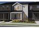 Charming townhome featuring gray siding, brick accents, and a welcoming front porch in a vibrant community at 3703 Rosebush Dr, Zebulon, NC 27597