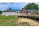 Back of the home featuring a deck, brick chimney, vinyl siding, and a well-maintained lawn at 3785 Little Creek Church Rd, Clayton, NC 27520