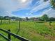 Expansive backyard featuring lush greenery, mature trees, garden and storage sheds against a bright sunny sky at 3785 Little Creek Church Rd, Clayton, NC 27520