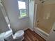 This bathroom features a white toilet, shower, and a bright window with a view of the outside at 3785 Little Creek Church Rd, Clayton, NC 27520