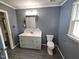 Bathroom with grey cabinets and tiled backsplash, tiled floors and safety bar at 3785 Little Creek Church Rd, Clayton, NC 27520