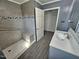 Accessible bathroom with tiled shower, bench, and gray vanity at 3785 Little Creek Church Rd, Clayton, NC 27520