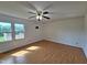 Bright bedroom features wood floors, a ceiling fan, and large window letting in natural light at 3785 Little Creek Church Rd, Clayton, NC 27520