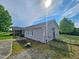 Home exterior with ramp access, vinyl siding, manicured landscaping, and a secure fenced yard at 3785 Little Creek Church Rd, Clayton, NC 27520