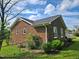 Side view of a brick home with white framed windows and a well-maintained lawn surrounded by a chain link fence at 3785 Little Creek Church Rd, Clayton, NC 27520