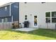 Backyard with a patio, grill, and green lawn with a wooden fence at 39 Principal Way, Clayton, NC 27520