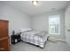 Bedroom with neutral walls, a window providing natural light, and a comfy bed with patterned linens at 39 Principal Way, Clayton, NC 27520