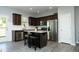 Well-lit kitchen featuring dark wood cabinets, stainless steel appliances, and a center island at 39 Principal Way, Clayton, NC 27520