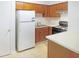 Functional kitchen with ample counter space, white appliances, and wood cabinetry at 403 Gooseneck Dr # A-1, Cary, NC 27513