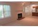 Bright living room with plush carpet, fireplace, and natural light at 403 Gooseneck Dr # A-1, Cary, NC 27513