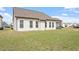 View of the green backyard and covered screened porch on a sunny day at 404 Lily Pad Ct, Zebulon, NC 27597