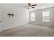 Neutral carpeted bedroom with a ceiling fan, large windows and TV mount at 404 Lily Pad Ct, Zebulon, NC 27597
