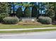 Well maintained Weavers Pond community entrance sign surrounded by mature landscaping, colorful flowers and lush green grass at 404 Lily Pad Ct, Zebulon, NC 27597