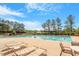 Resort-style pool area with comfortable lounge chairs, surrounded by lush landscaping and clear blue skies at 404 Lily Pad Ct, Zebulon, NC 27597