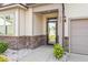 Inviting front entrance with a modern glass door, stone accents, and a covered porch at 404 Lily Pad Ct, Zebulon, NC 27597